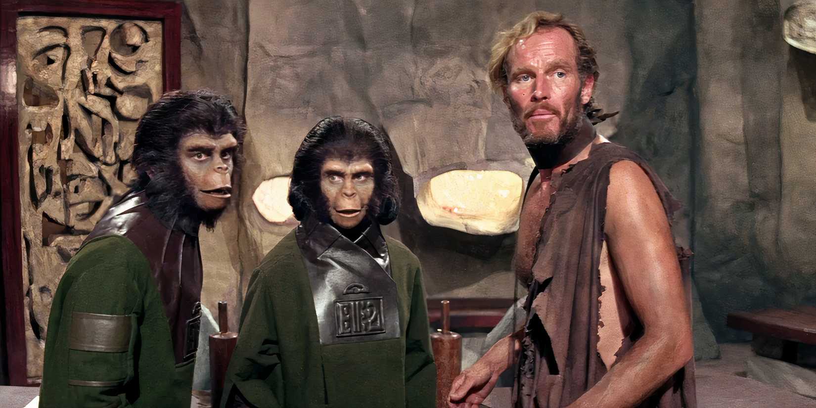 Taylor looks over his shoulder while standing with Zira and Cornelius in Planet of the Apes