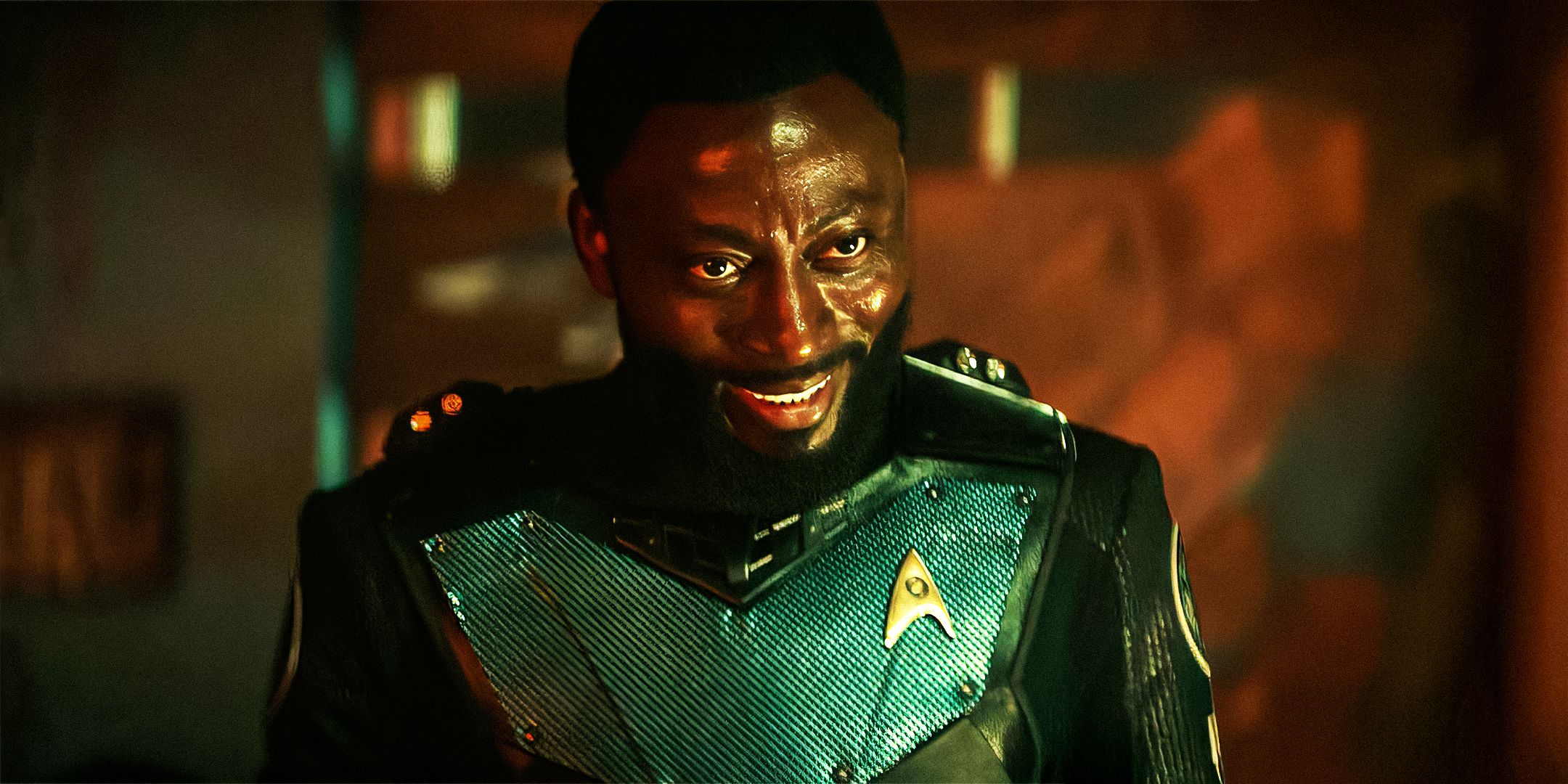 Dr. M'Benga smiling with dark lighting in Star Trek: Strange New Worlds.