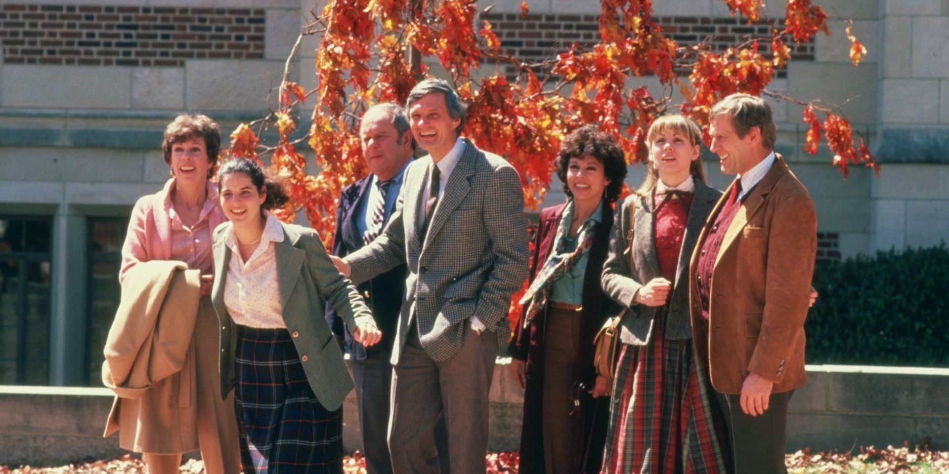 The cast of The Four Seasons movie smiling in front of a building