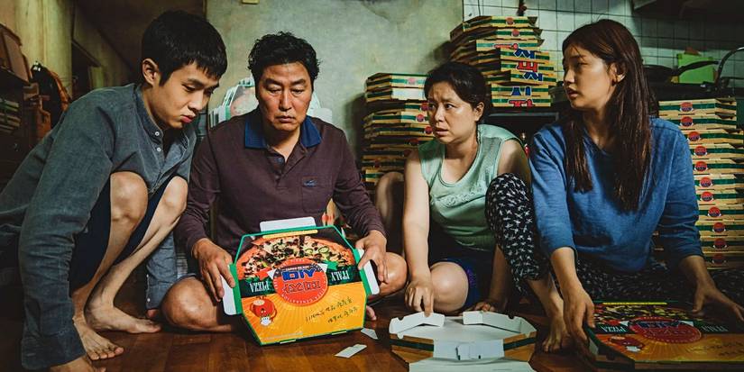 The family gathers around folding pizza boxes in Parasite 