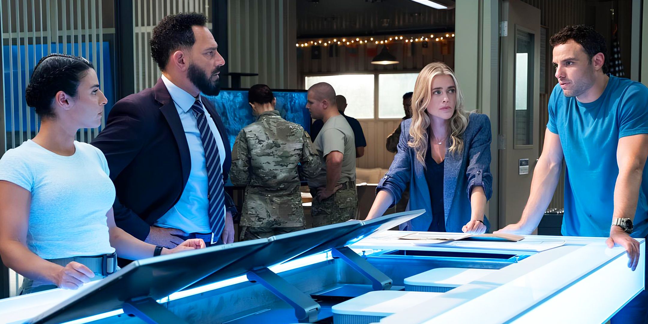 Morales, Hassani, Bex, and Shane around a computer console in The Hunting Party