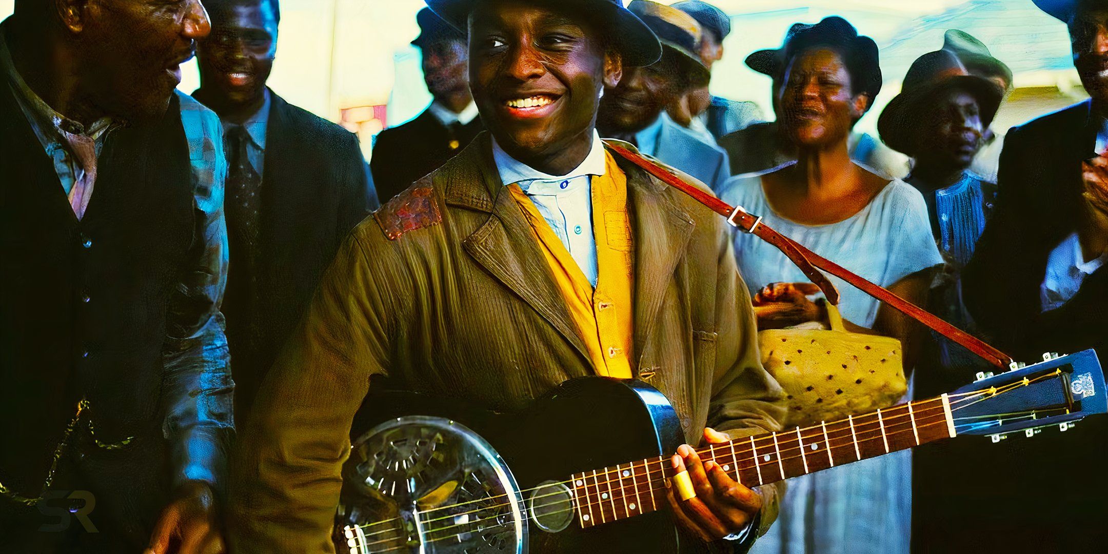 Sammie playing his guitar and smiling in Sinners