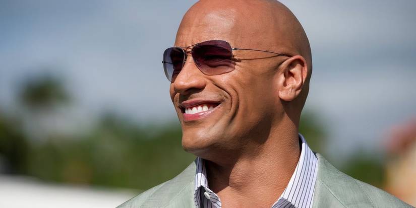 Spencer (The Rock) usando óculos escuros e olhando para o lado em Ballers