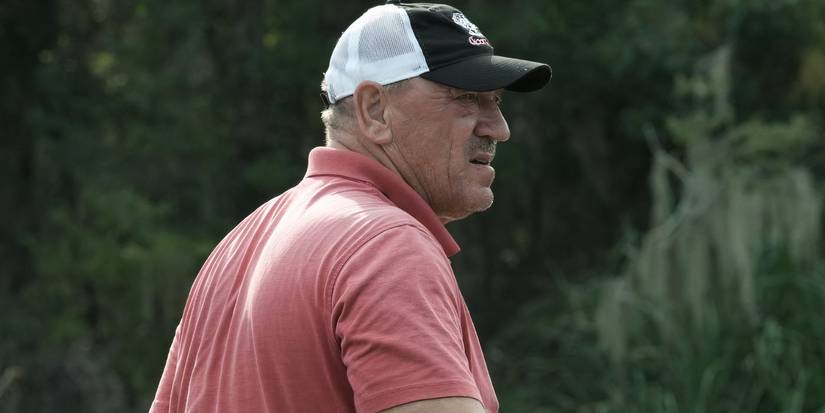 Troy Landry Swamp People on boat looking worried in peach shirt and hat