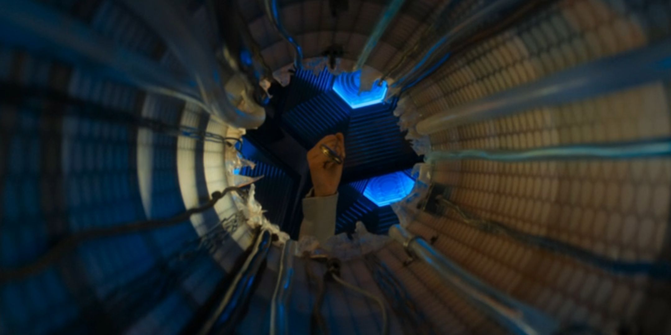The Thirteenth Doctor holding a fob watch over a hole in the TARDIS in Doctor Who