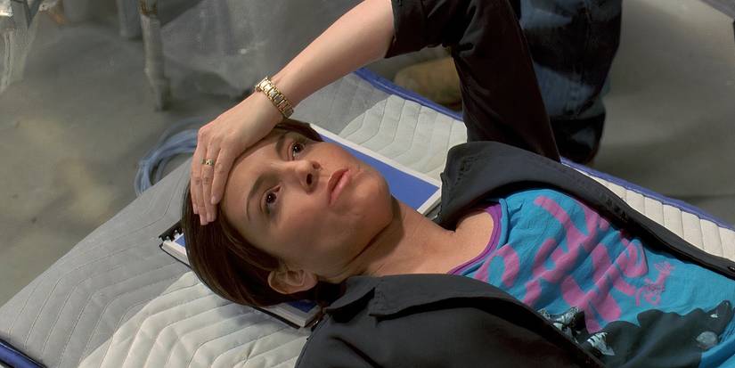 Tina Fey as Liz Lemon lying down backstage, looking defeated with her hand on her head, in 30 Rock's pilot.