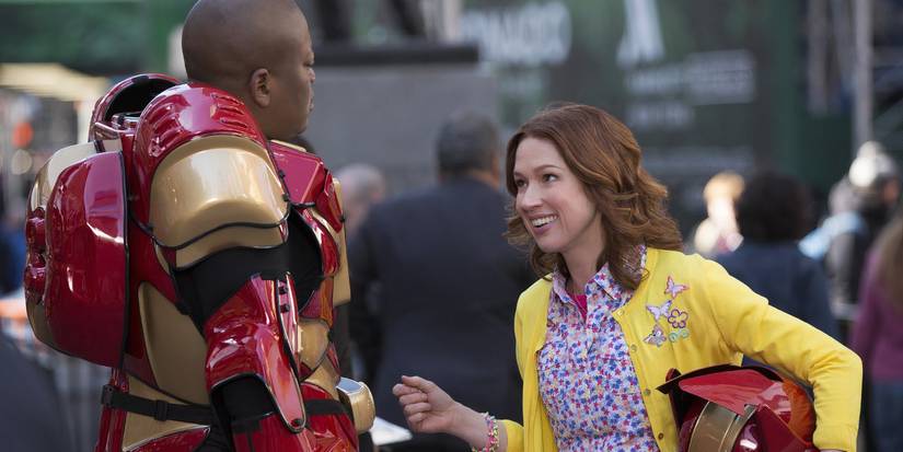 Kimmy (Ellie Kemper) convincing Titus (Tituss Burgess), who is wearing a robot costume, not to give up on acting while standing in Times Square in the Unbreakable Kimmy Schmidt pilot.