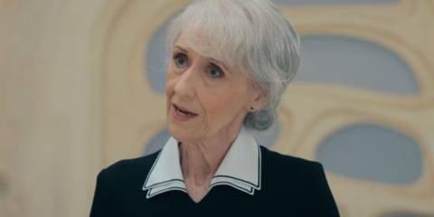 Anita Dobson as Mrs. Flood looking at something curiously in the Doctor Who episode 