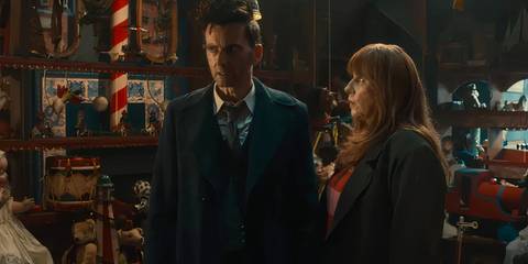 The Fourteenth Doctor and Donna looking nervous in the Toymaker's toyshop as they are surrounded by puppets in the Doctor Who episode 
