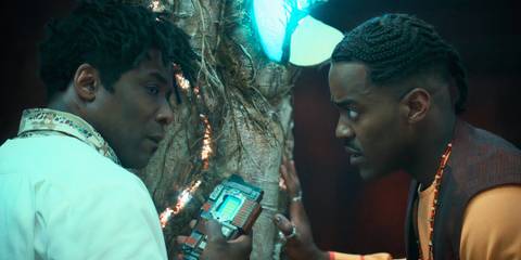 The Barber holding an electronic device on the left and the Doctor watching him on the right