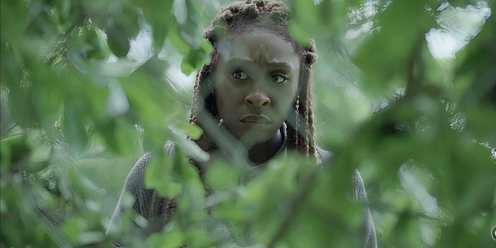 Cynthia Erivo as Holly Gibney in The Outsider, hidden among green leaves
