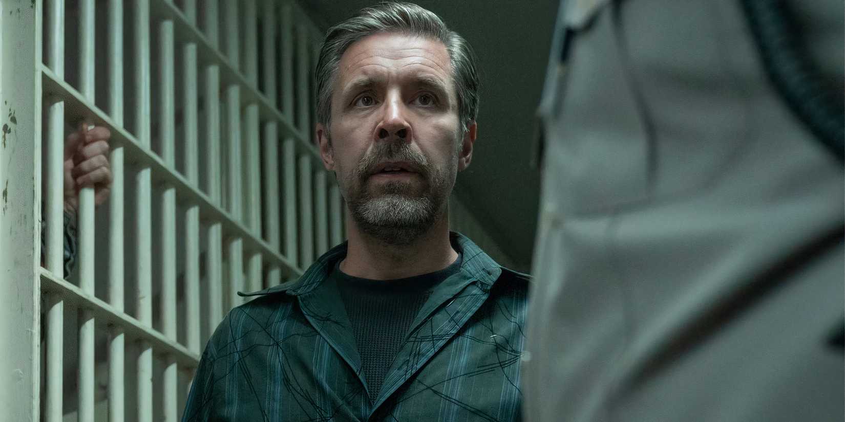 Paddy Considine as Claude Bolton standing outside of a jail cell in The Outsider