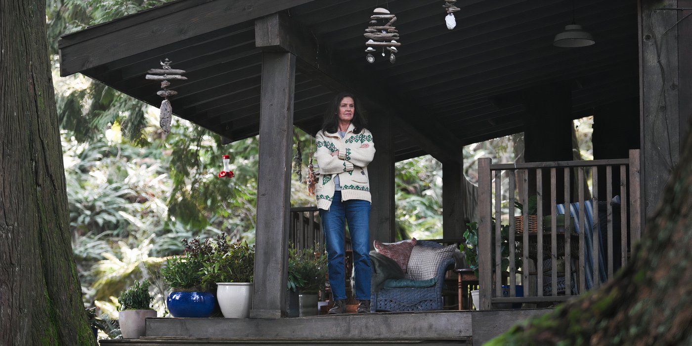 Mary Dove Shaw standing on her porch in the woods