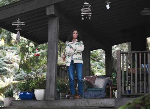 Mary Dove Shaw standing on her porch in the woods