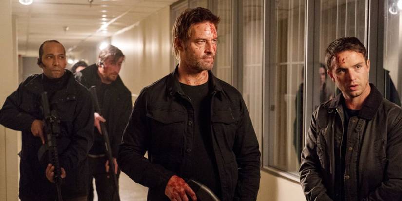 Will (Josh Holloway) holding a gun with other Resistance members in Colony.