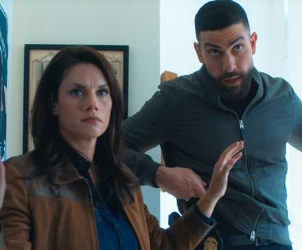 Maggie and OA standing in a doorway with their hands up in FBI