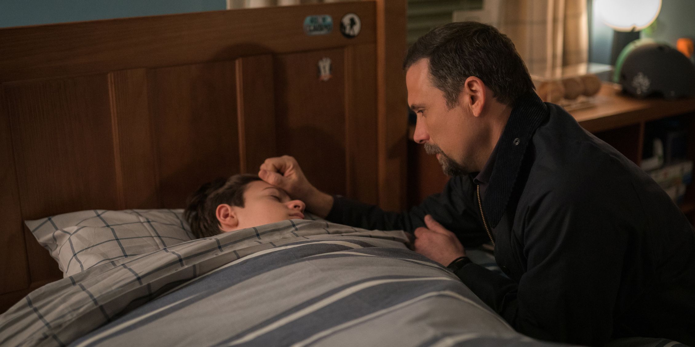 FBI Jubal kneels by Tyler's bed and puts his hand on Tyler's head