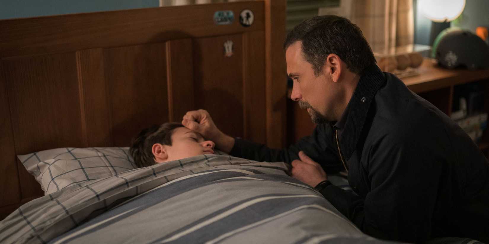 FBI Jubal kneels by Tyler's bed and puts his hand on Tyler's head