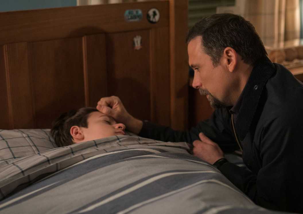 FBI Jubal kneels by Tyler's bed and puts his hand on Tyler's head