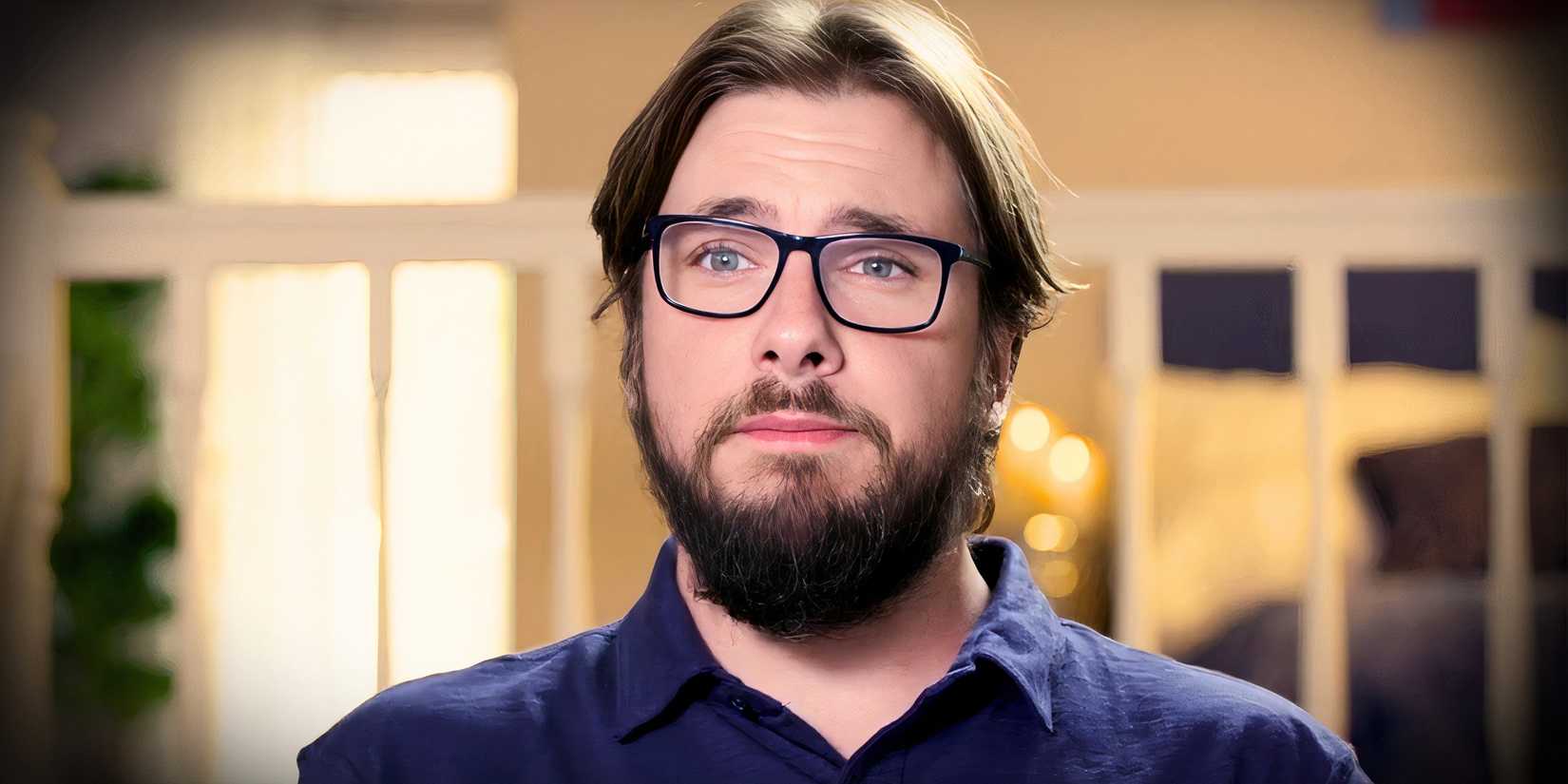 90 day fiance star colt johnson looking somber in eyeglasses with a yellow background