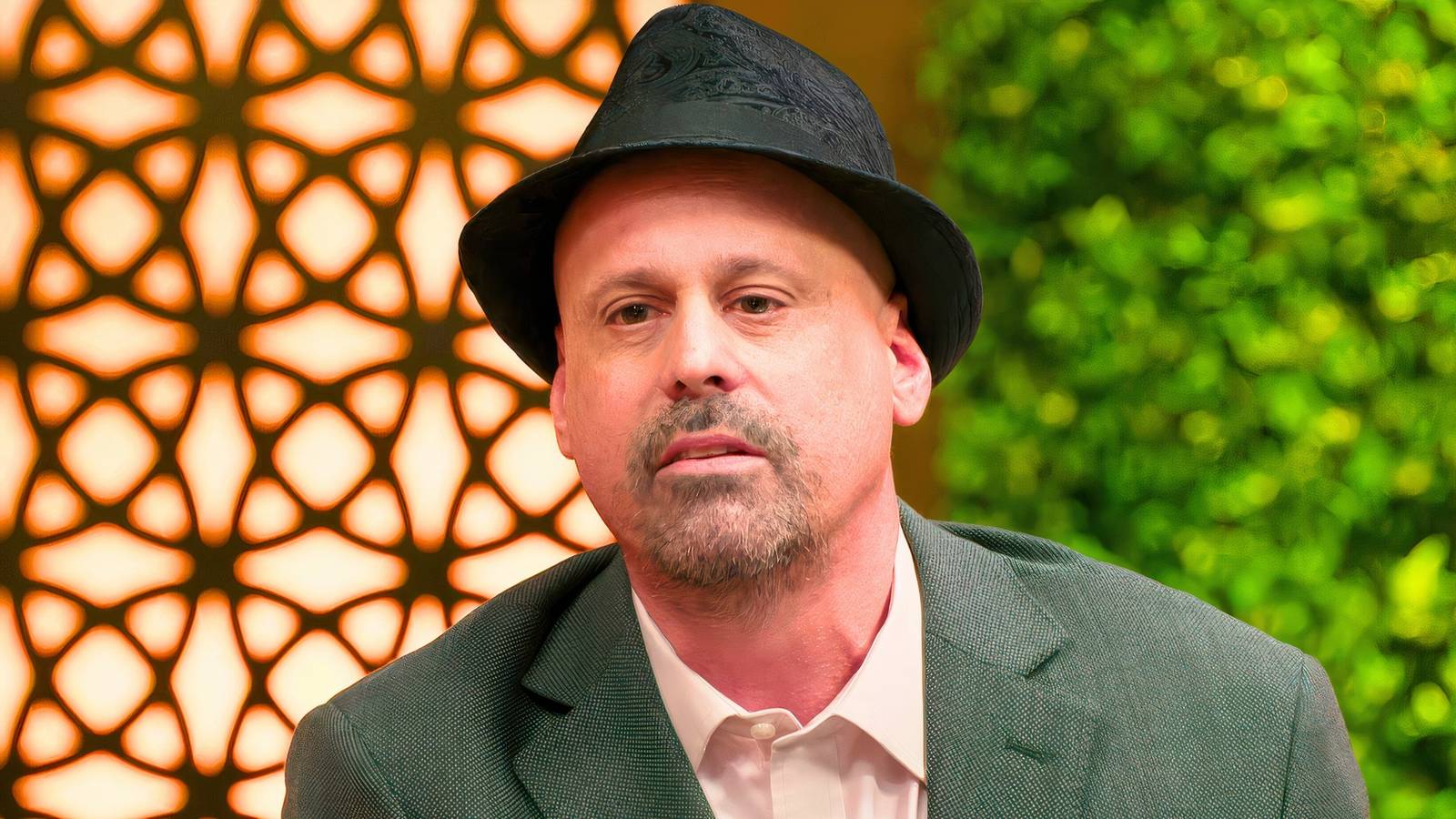 90 day fiance star gino palazzolo in a hat looking upset with outdoor background
