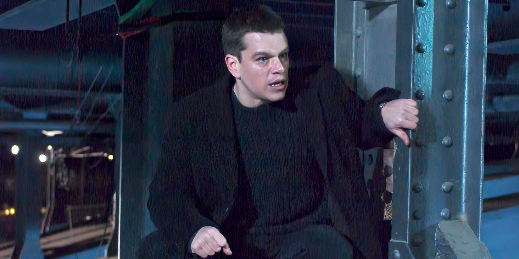 Matt Damon agacha ao lado de uma viga de aço em uma cena de The Bourne Supremacy