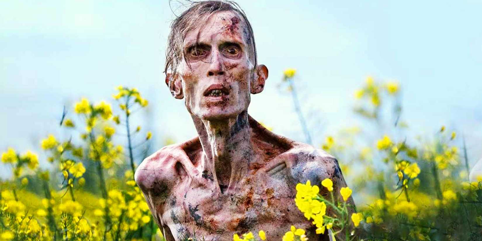 Angus Neil als Infizierter, umgeben von gelben Blumen in 28 Years Later