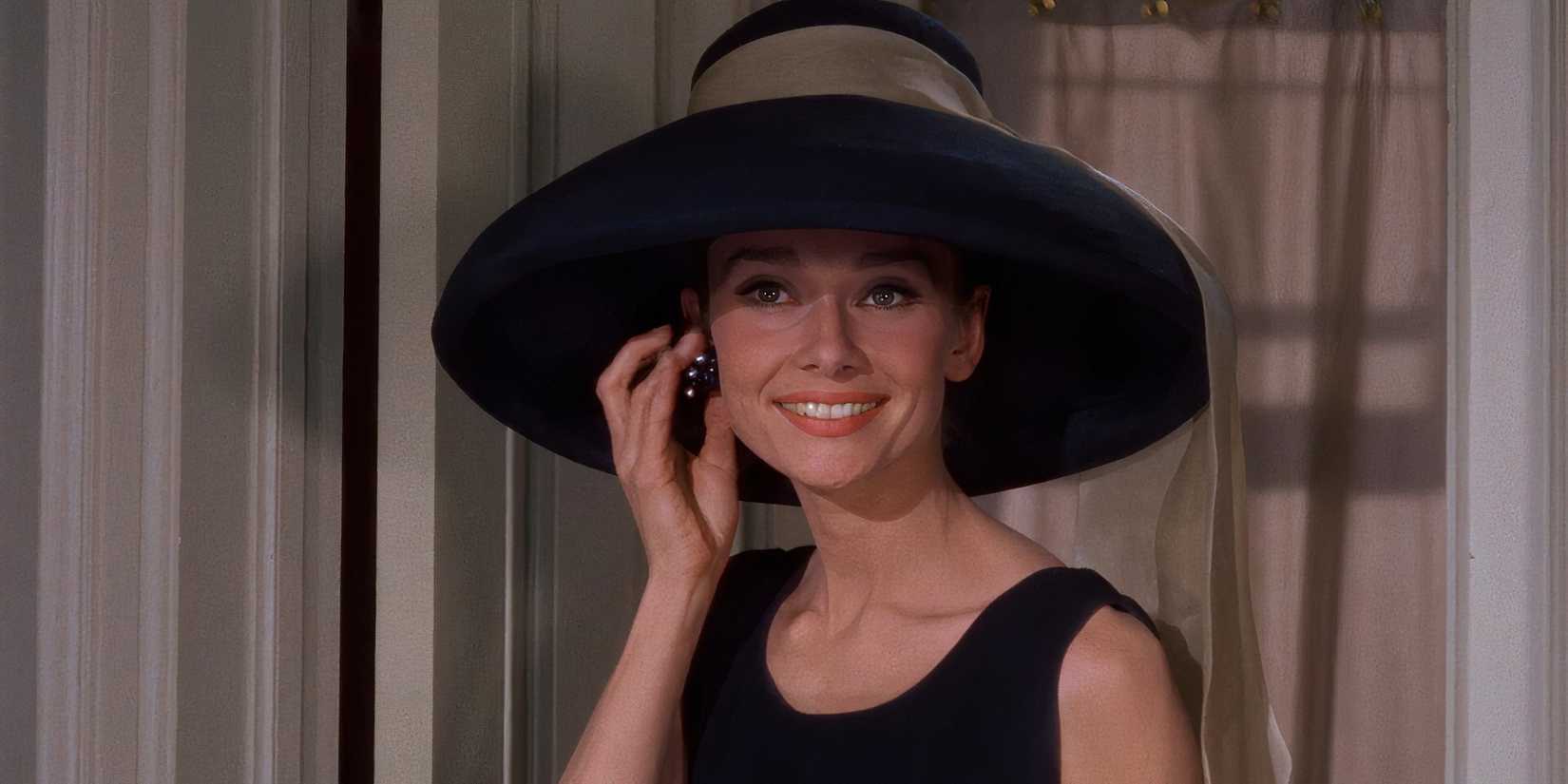 Holly smiles while adjusting her earring in Breakfast at Tiffany's