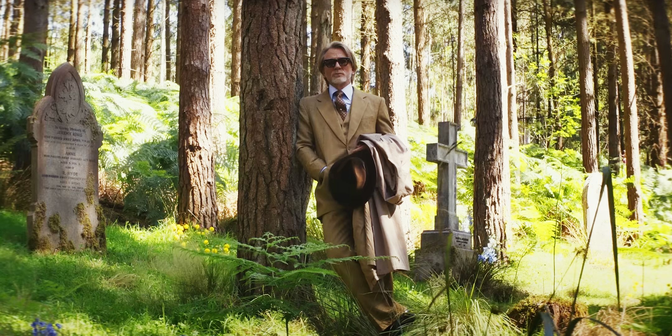 Daniel Craig Leaning Up Against a Tree in a Cemetery in Knives Out Wake Up Dead Man