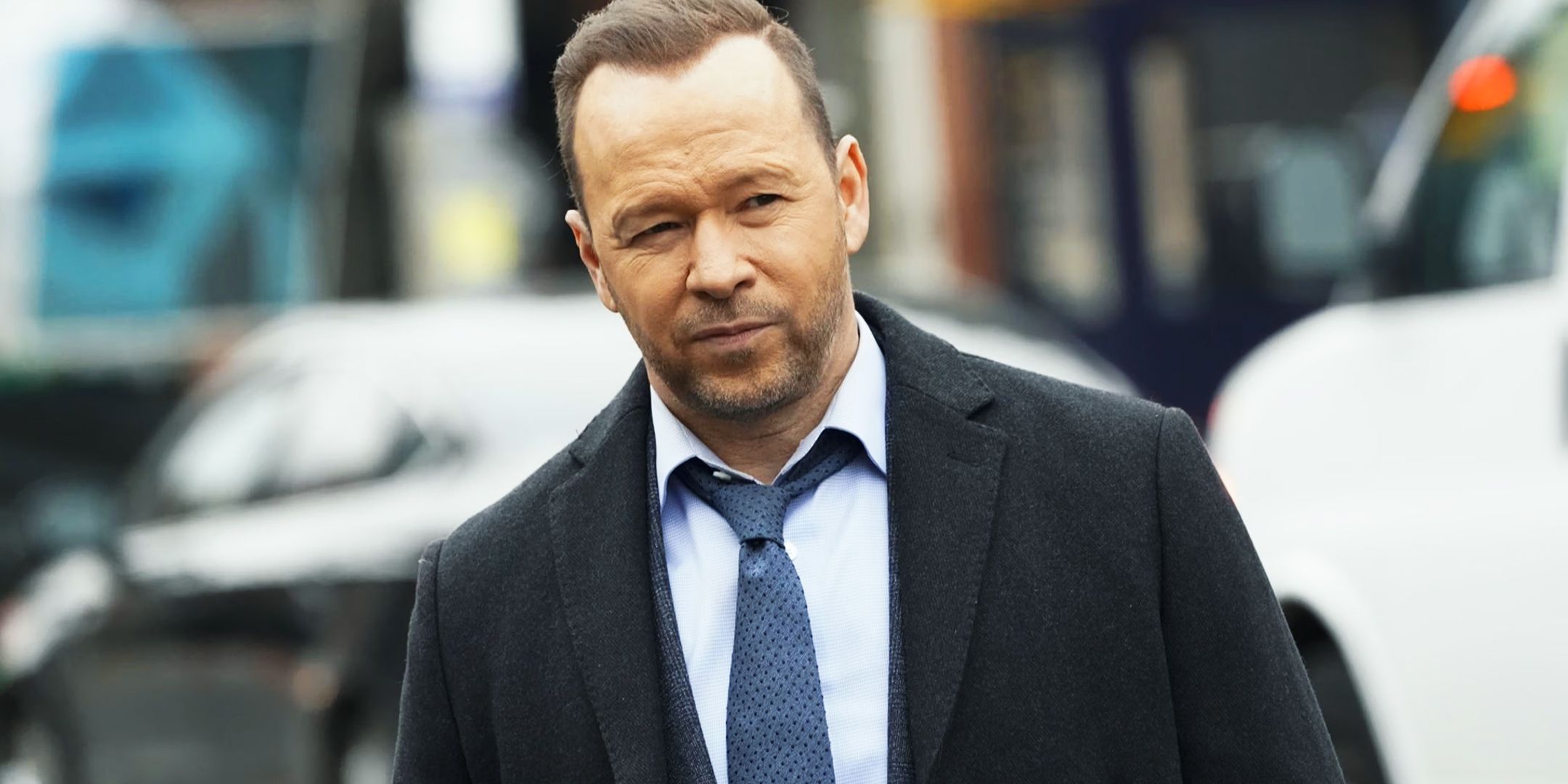 Danny Reagan standing in front of a busy street in Blue Bloods 