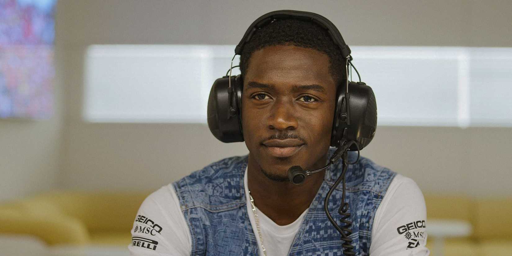 Damson Idris as Joshua Pearce wearing communication headphones in F1