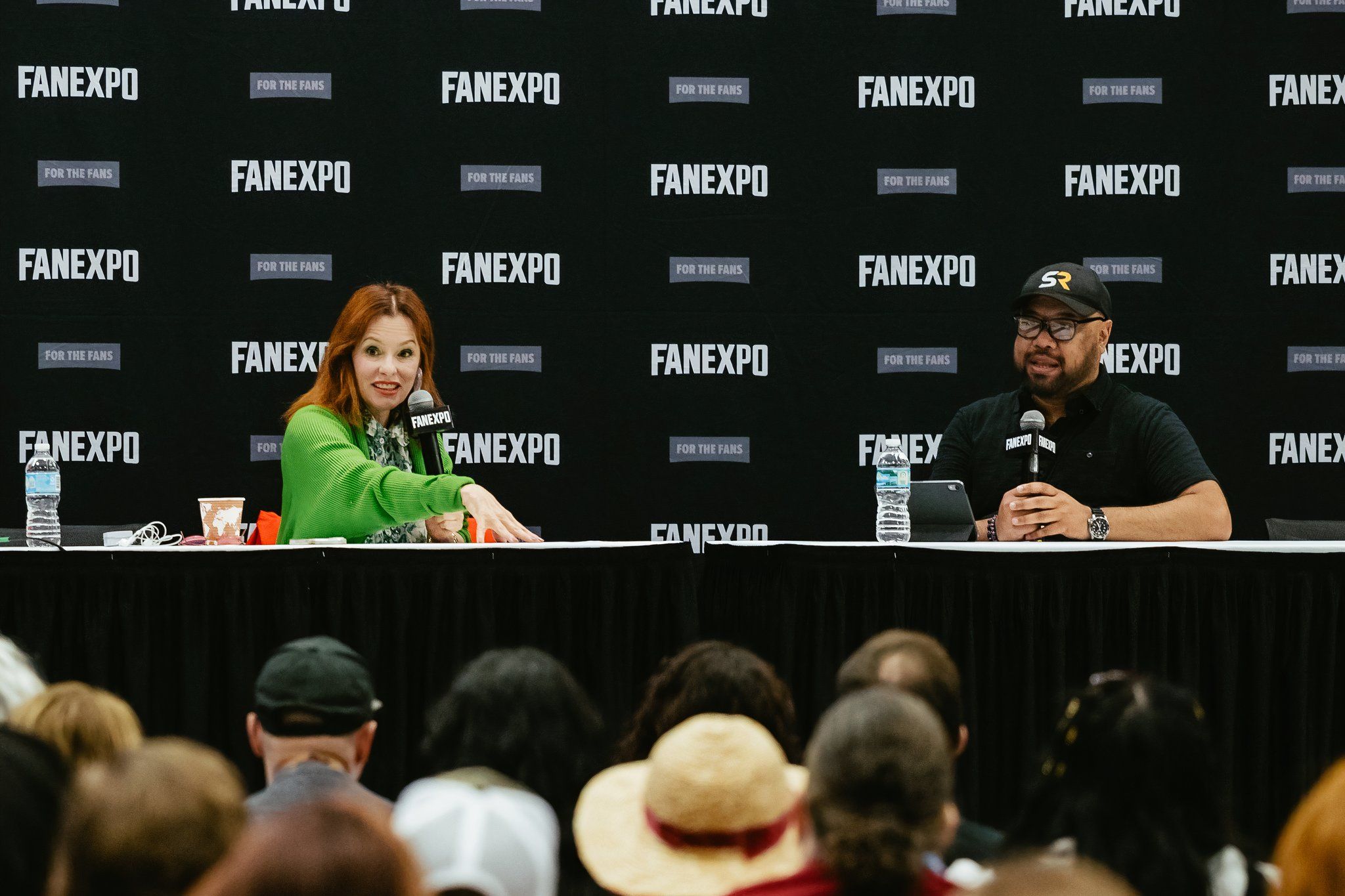 Joe Deckelmeier from ScreenRant on stage at FAN EXPO Dallas with White Lotus star Parker Posey