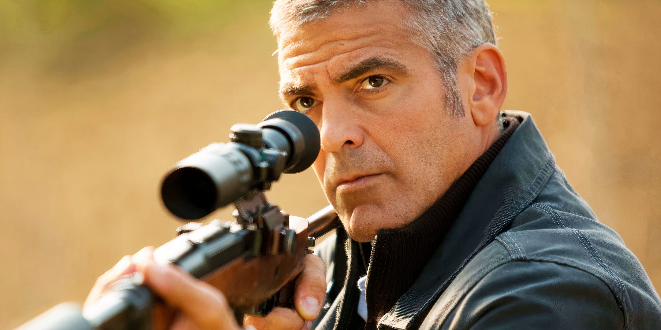 George Clooney aims a sniper rifle in The American