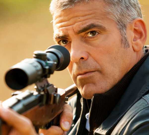 George Clooney aims a sniper rifle in The American