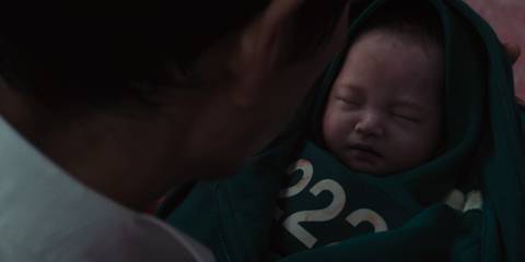 Gi-hun holding Jun-hee's baby in Squid Game season 3, episode 6