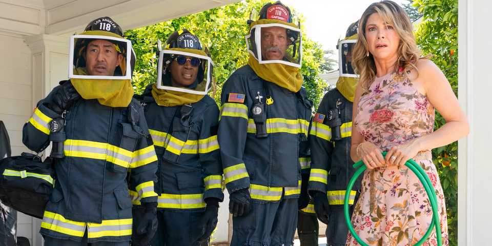 A group of first responders in bee gear next to a scared woman in 9-1-1