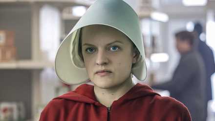 June Osborne (Elisabeth Moss) looking upset, wearing a handmaid's outfit in The Handmaid's Tale.