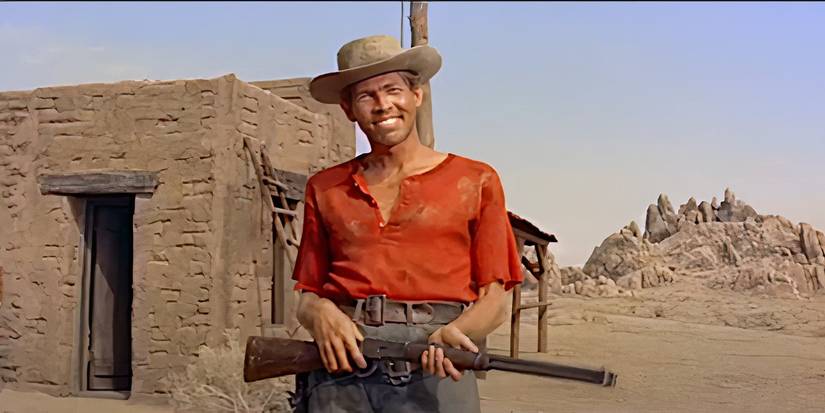 James Coburn as Whit, smiles while holding a rifle in a scene from Ride Lonesome