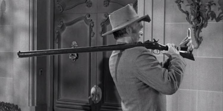 Jed (Buddy Ebsen) with a gun over his shoulder in The Beverly Hillbillies Jed Becomes a Banker.