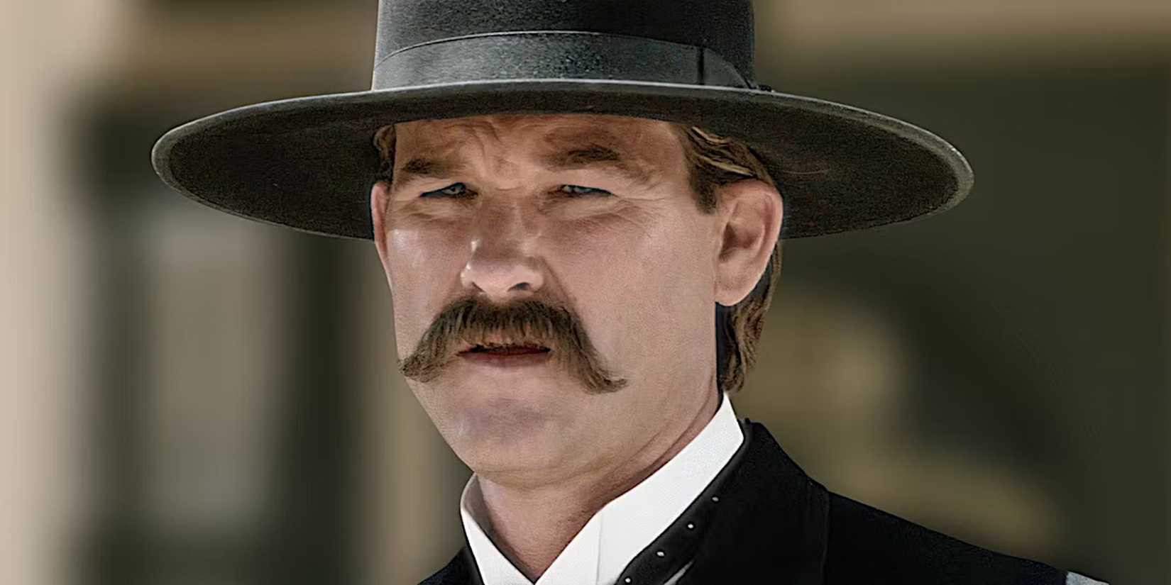 Kurt Russell folds his eyes in the sun in a tombstone scene