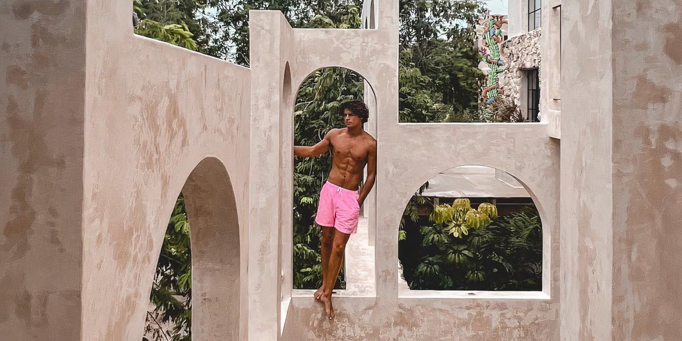 Love Island USA Season 7's Nic Vansteenberghe posing on a stone structure.