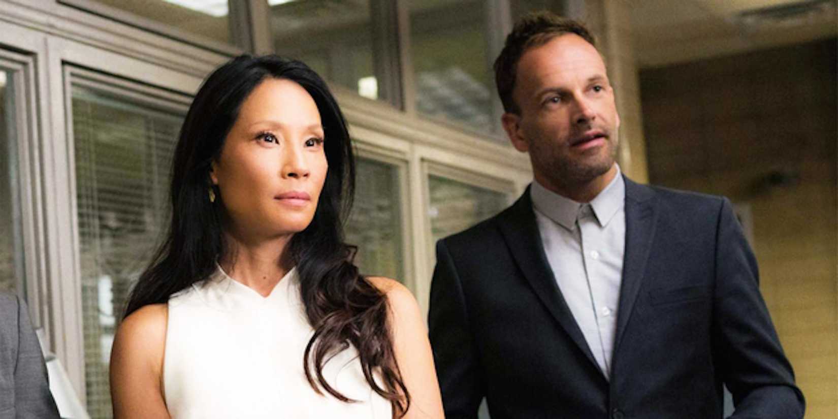 Joan Watson (Lucy Liu) e Sherlock (Johnny Lee Miller) em um escritório em Elementary