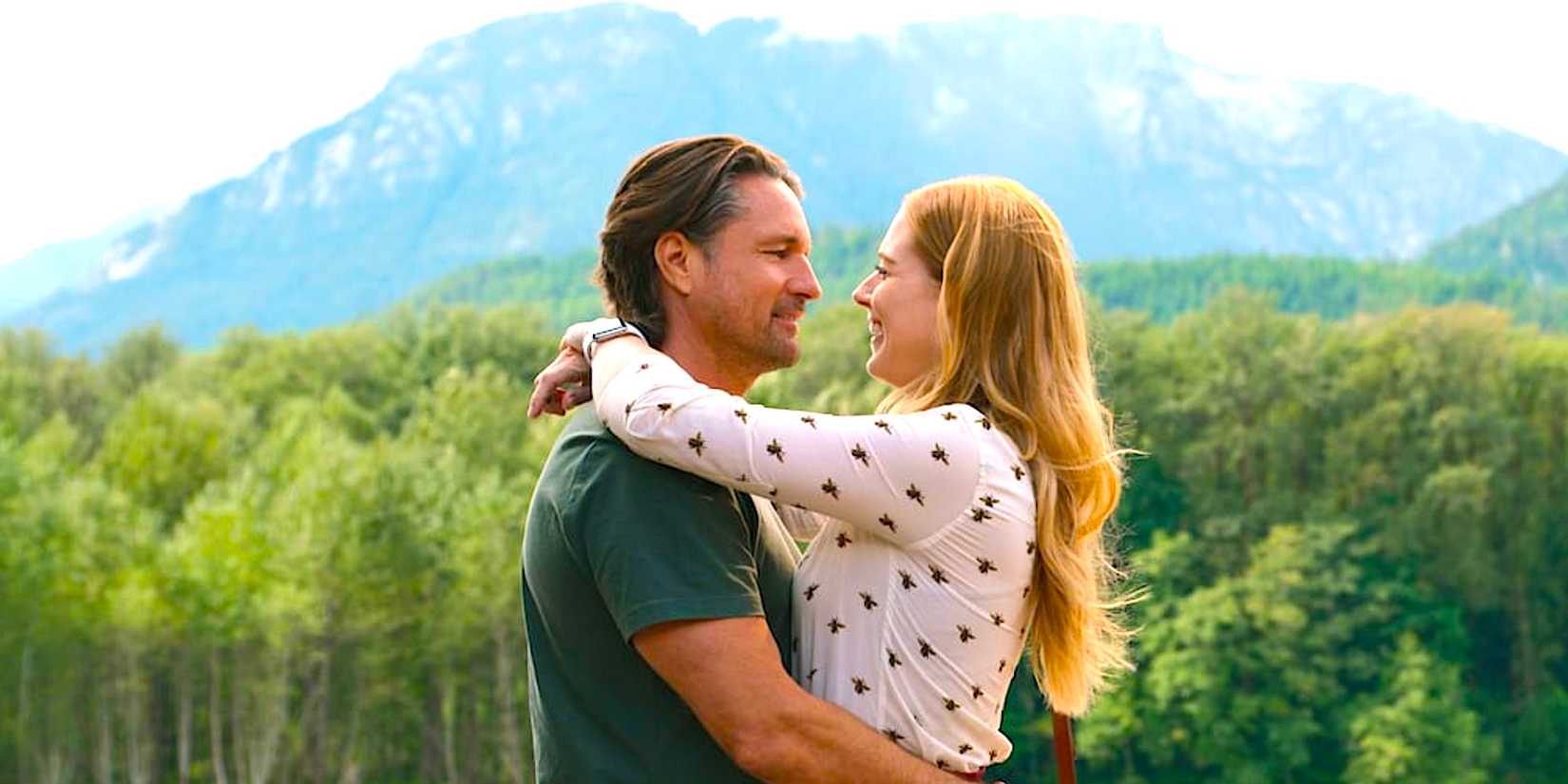 Martin Hendersons Jack umarmt Alexandra Breckenridges Mel vor der bergigen Kulisse von Virgin River