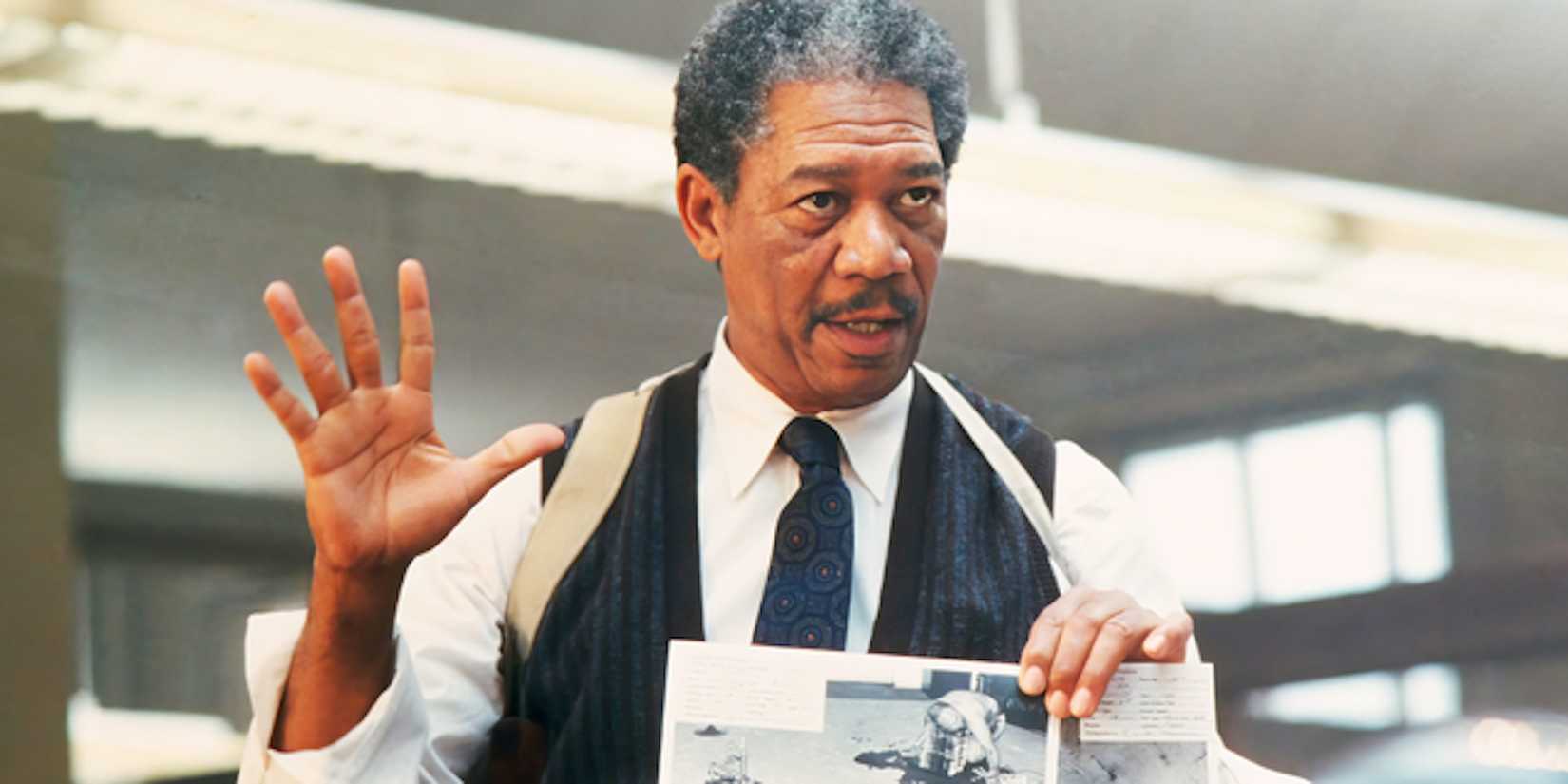 Morgan Freeman's William Somerset stands in an office holding a note in Se7en