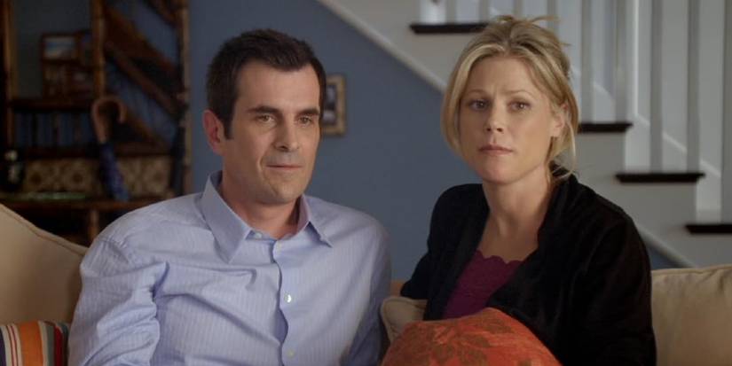 Phil and Claire sitting together on the couch in Modern Family pilot