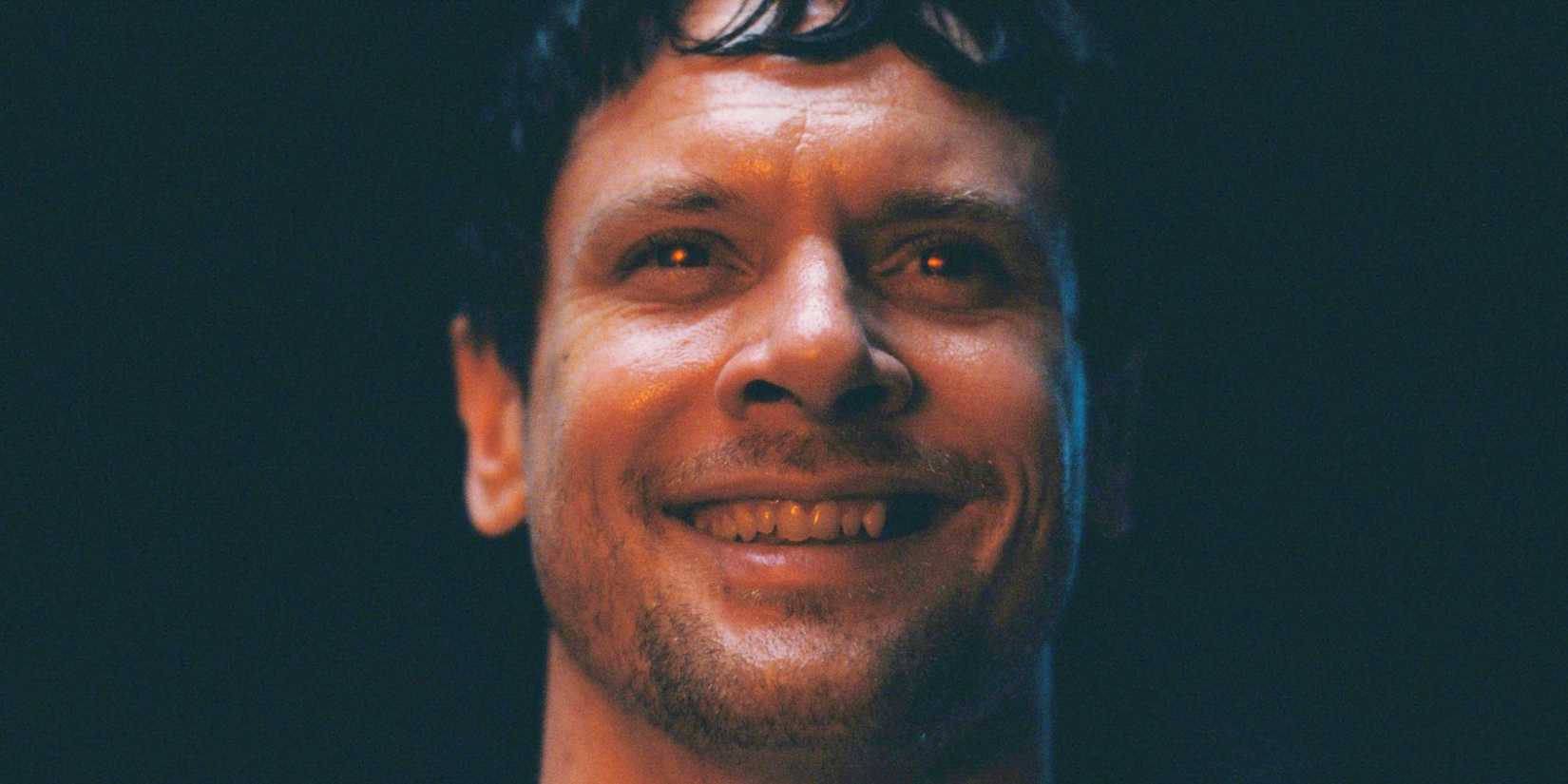 Remmick sorri com os olhos brilhando em vermelho em Sinners