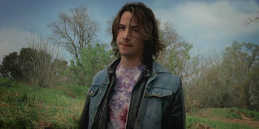 Keanu Reeves looks angry while standing in the weeds in River's Edge