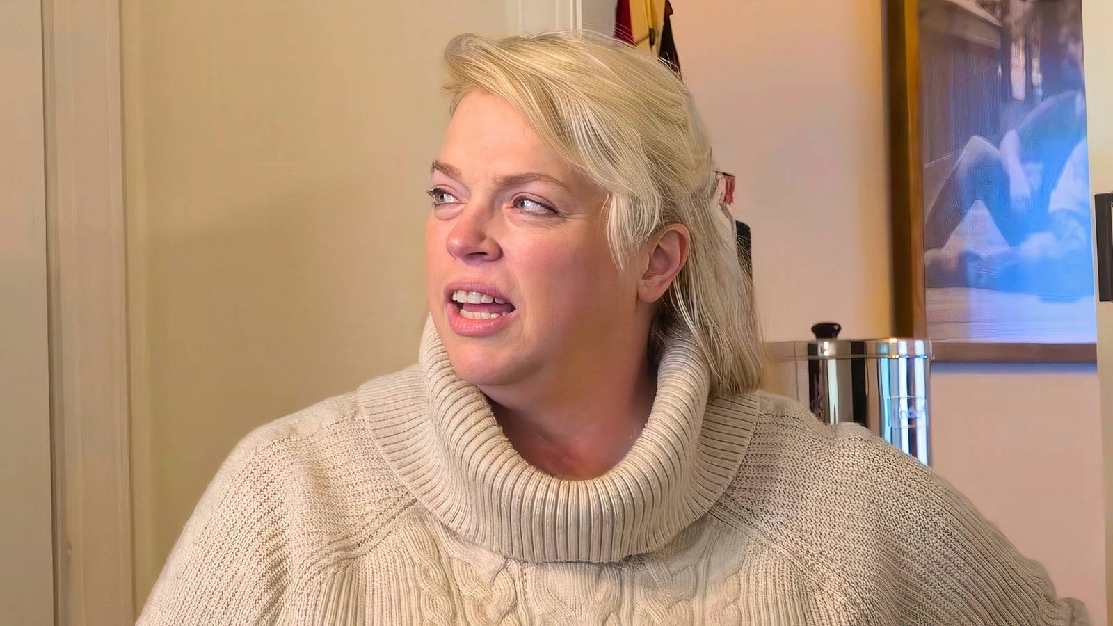 sister wives star janelle brown in a cream turtleneck sweater talking in a kitchen