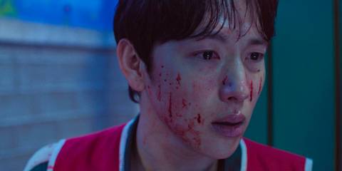 Myung-gi (Yim Si-wan) with bloodstains on his face and shocked in Squid Games Season 3 Ep 2