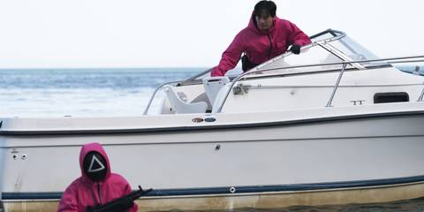 Two pink soldiers board a boat in Squid Game season 3